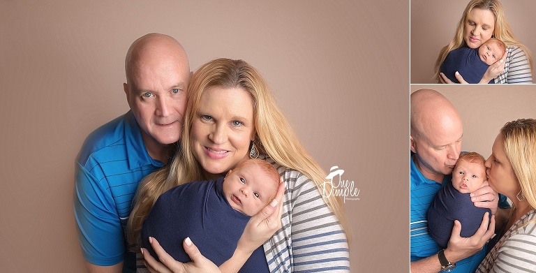 Family poses with swaddled newborn 